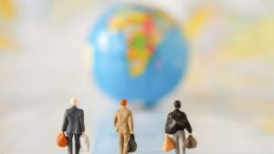 Plastic travelers facing blurred globe