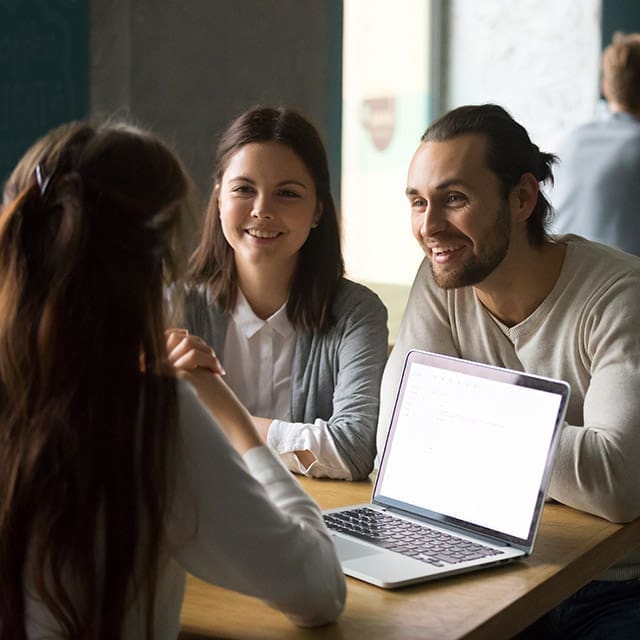 Young couple chatting to mortgage broken about refinancing their home loan