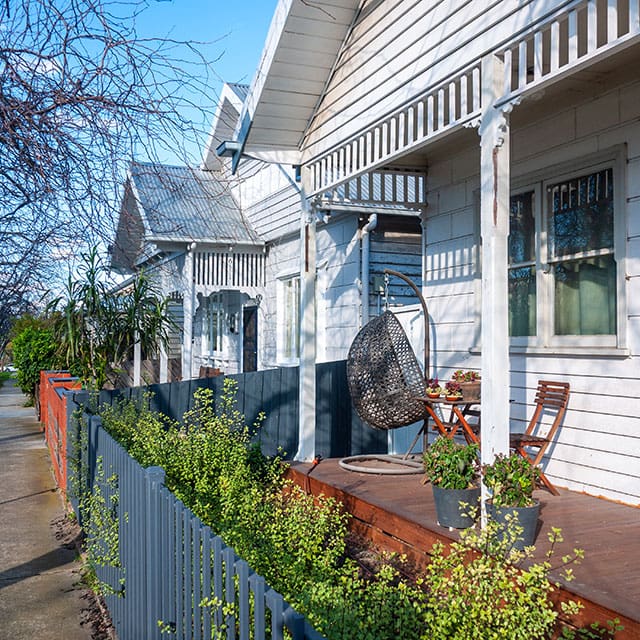 Porch of weatherboard residential house in a Australian suburb. Pedestrian sidewalk in a quiet neighbourhood. Melbourne, VIC Australia