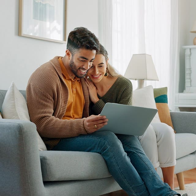 Young couple on couch in their new home.
