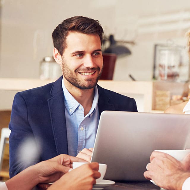 Young mortgage broker with laptop in cafe