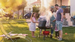 Picture of big happy family making barbeque in their backyard. Family time on sunny summer day.