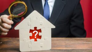 Home buying question, puzzle house with question mark and business man with magnifying glass.